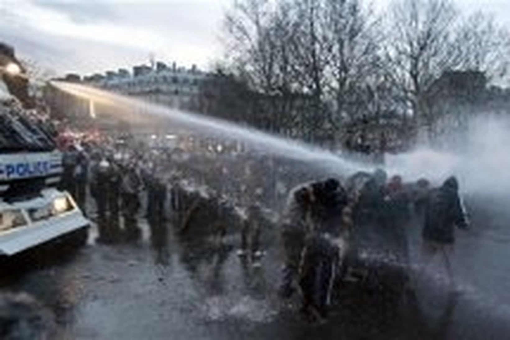 Lögreglan sprautar vatni á mótmælendur á Place de la Republique …