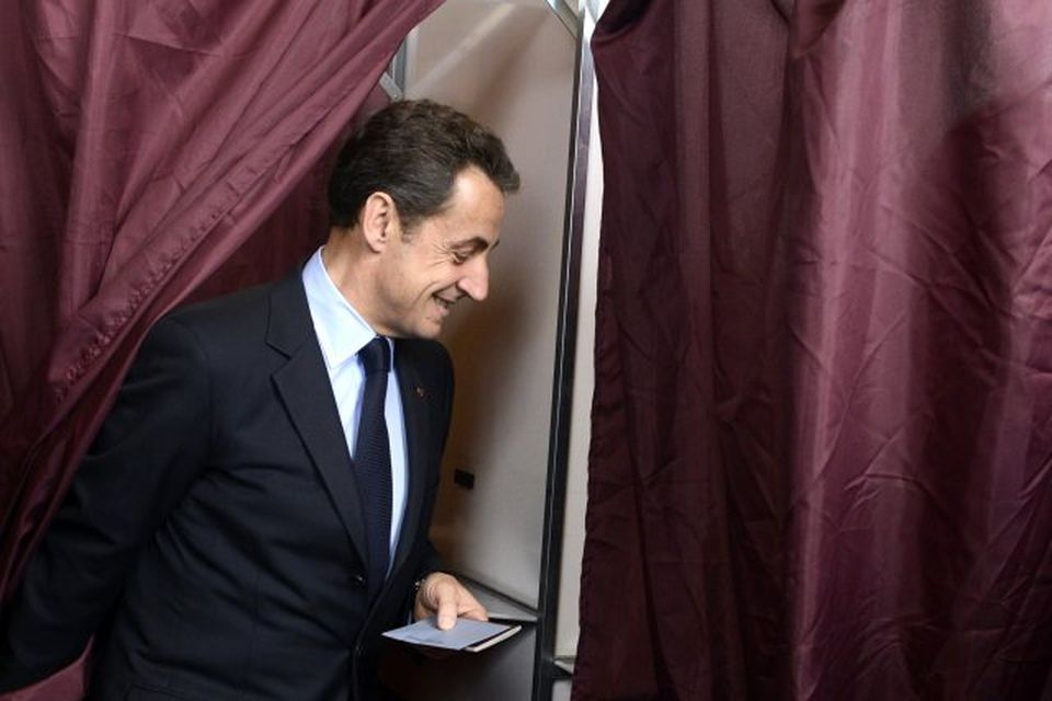 Nicolas Sarkozy kemur út úr kjörklefanum í dag