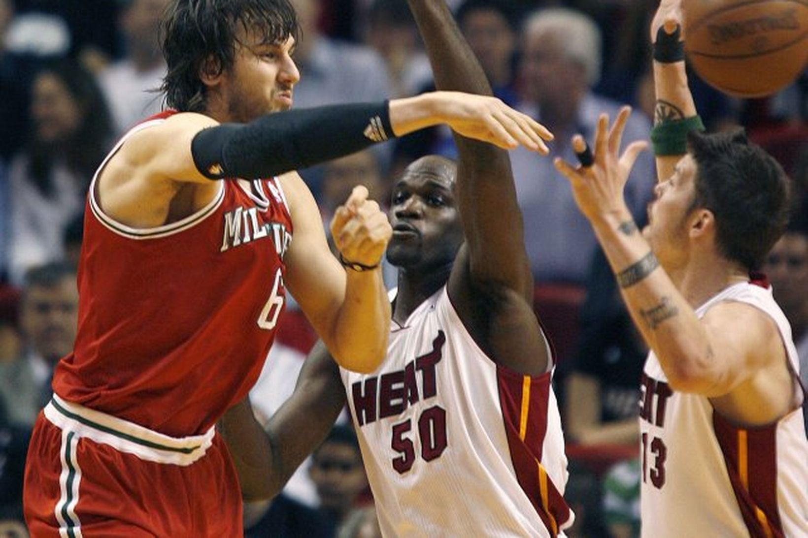 Andrew Bogut miðherji Milwaukee sendir boltann framhjá Joel Anthony og …