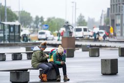 Ferðamenn leggja á ráðin á steinsteyptu plani í miðborg Reykjavíkur.