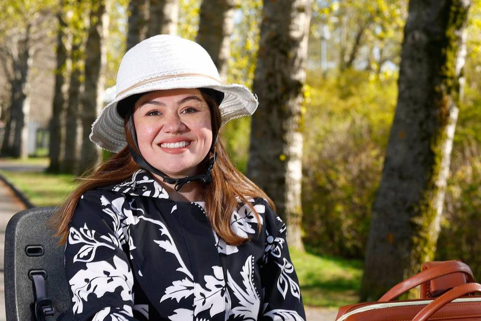 Eva er á rauðu rafmagnshjóli með körfu undir töskuna sína.