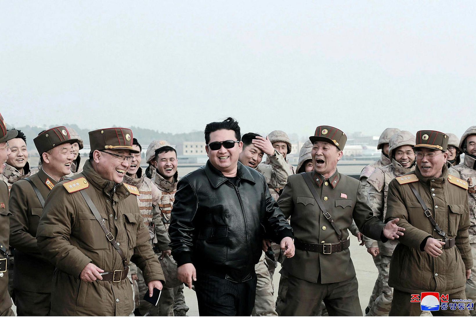 Kim Jong-un glaðbeittur ásamt hermönnum á meðan á tilraunaskotinu stóð.