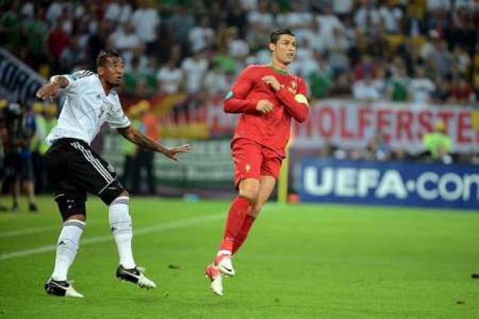 Jerome Boateng spyrnir boltanum en Cristiano Ronaldo sækir að.