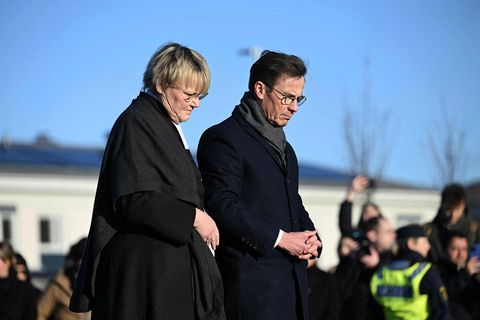 Ulf Kristersson, forsætisráðherra Svíþjóðar, og kona hans Birgitta votta hér virðingu sína fyrir utan skólann …