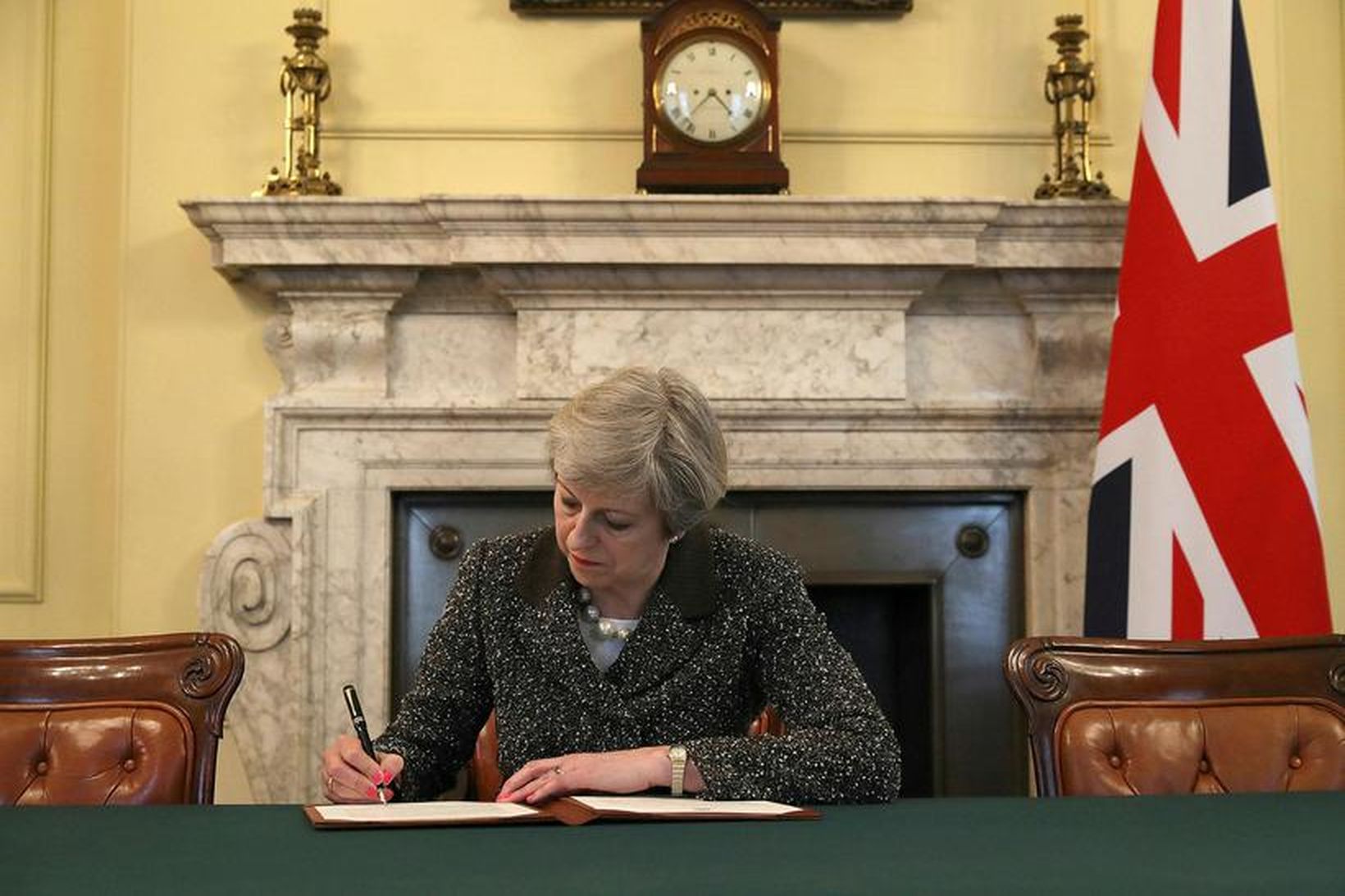 Theresa May, forsætisráðherra Bretlands, undirritar bréfið í dag.