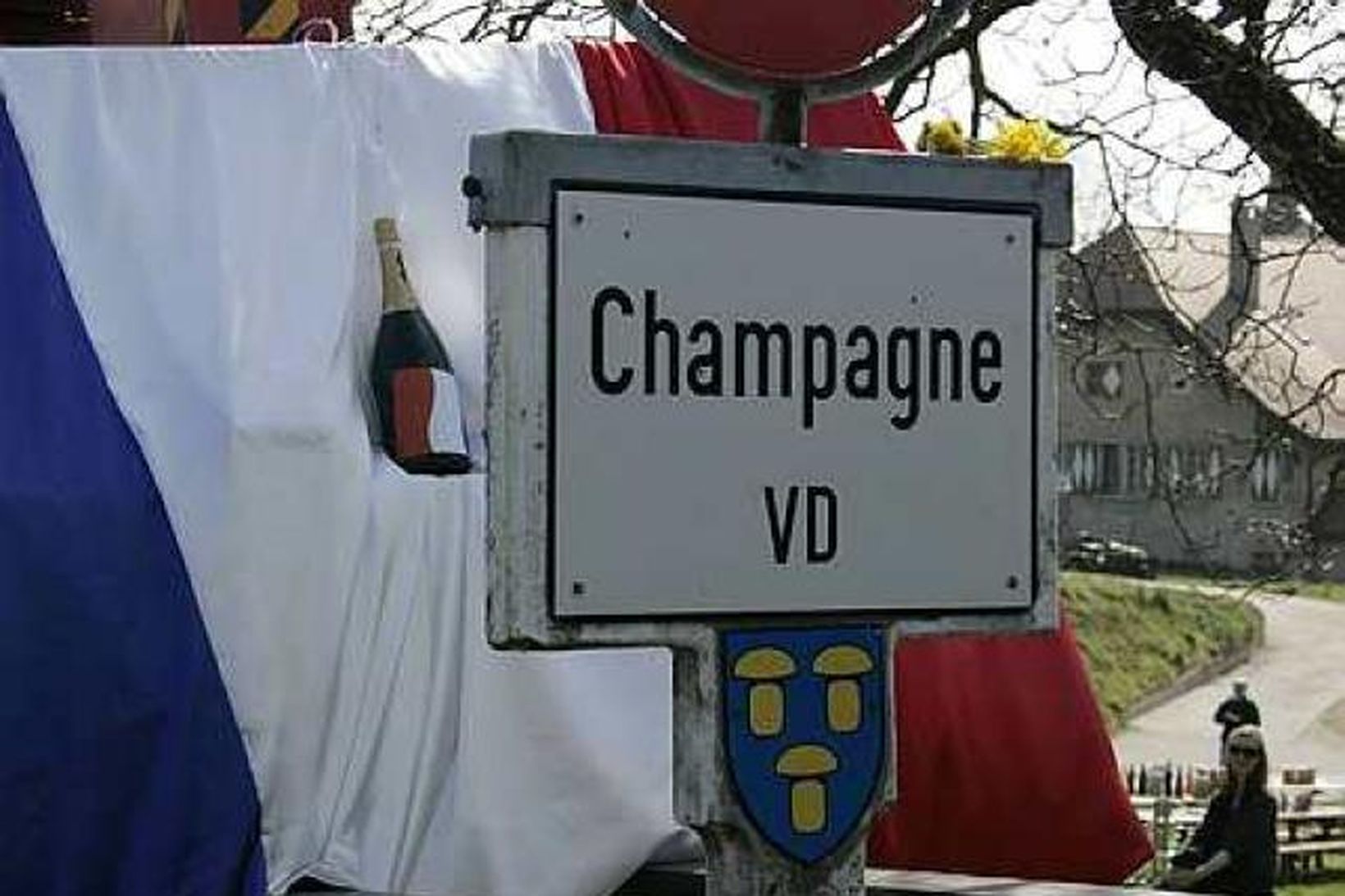 Franski fáninn skyggir á bæjarnafnið Champagne þegar ekið er inn …