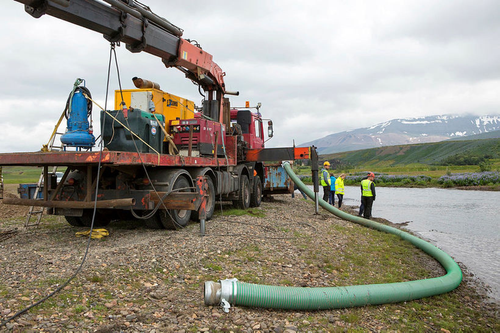 Verktakar vinna að hreinsun aurs úr laxveiðiánni.