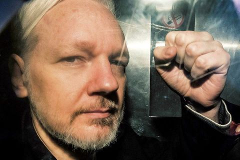 Julian Assange steytir hnefann um borð í fangaflutningabíl í London 1. maí síðastliðinn.