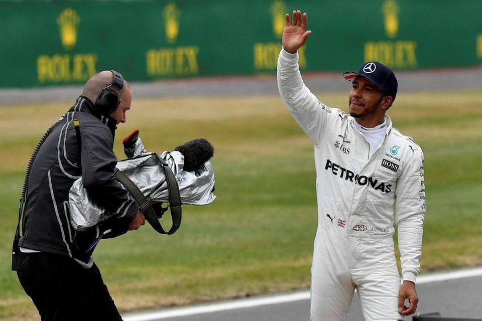 Lewis Hamilton veifar löndum sínum í stúkum Sivlerstone að tímatöku lokinni.