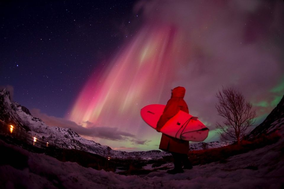 Brimbrettakappi skoðar norðurljósin á himni yfir Lofoten í Noregi í mars. Norðurljósin voru sérstaklega björt …