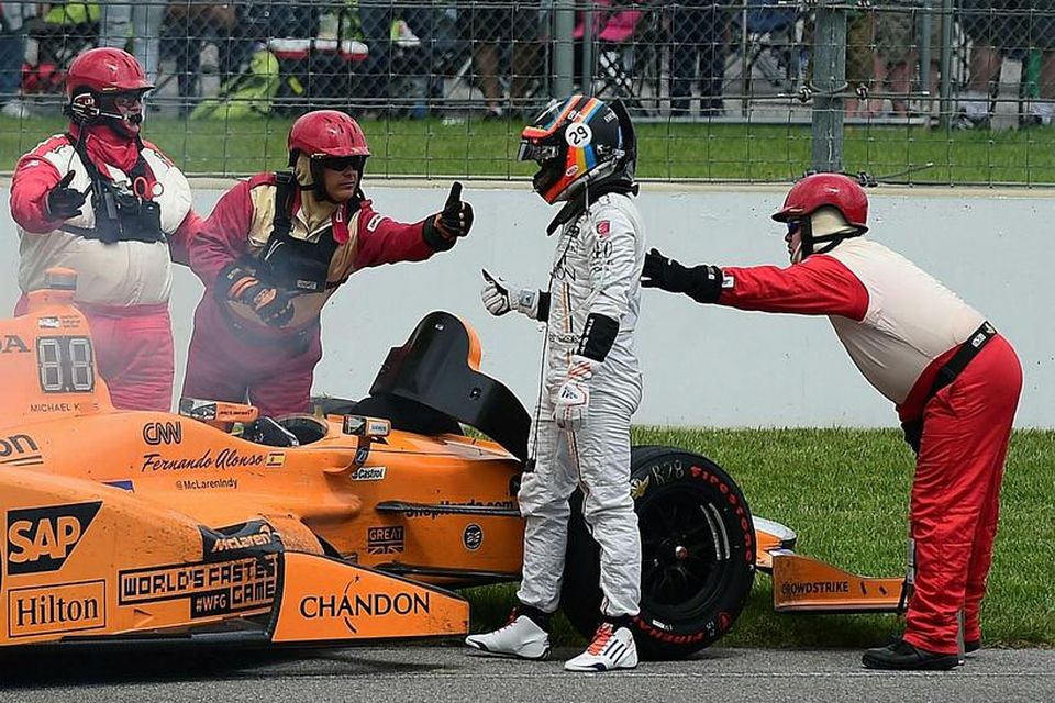 Fernando Alonso yfirgefur bíl sinn í Indianapolis eftir að vélin gaf sig.