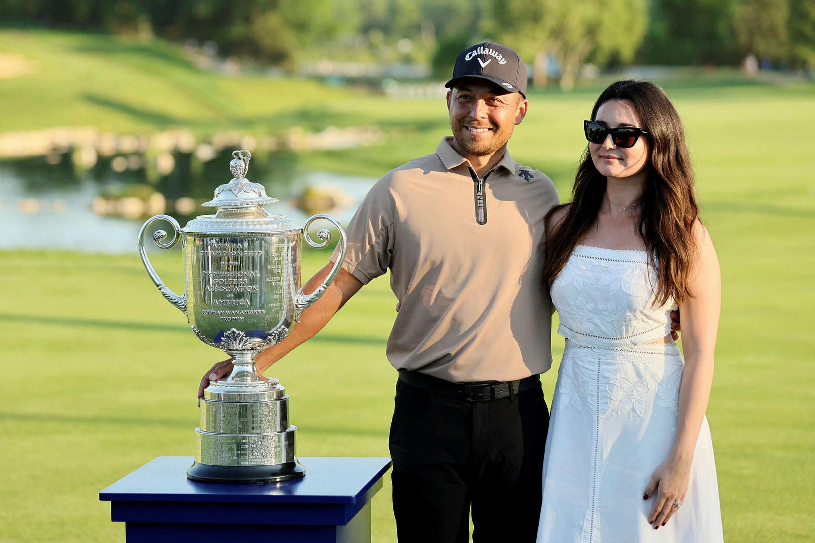 Xander Schauffele og Maya eiginkona hans með bikarinn glæsilega í …