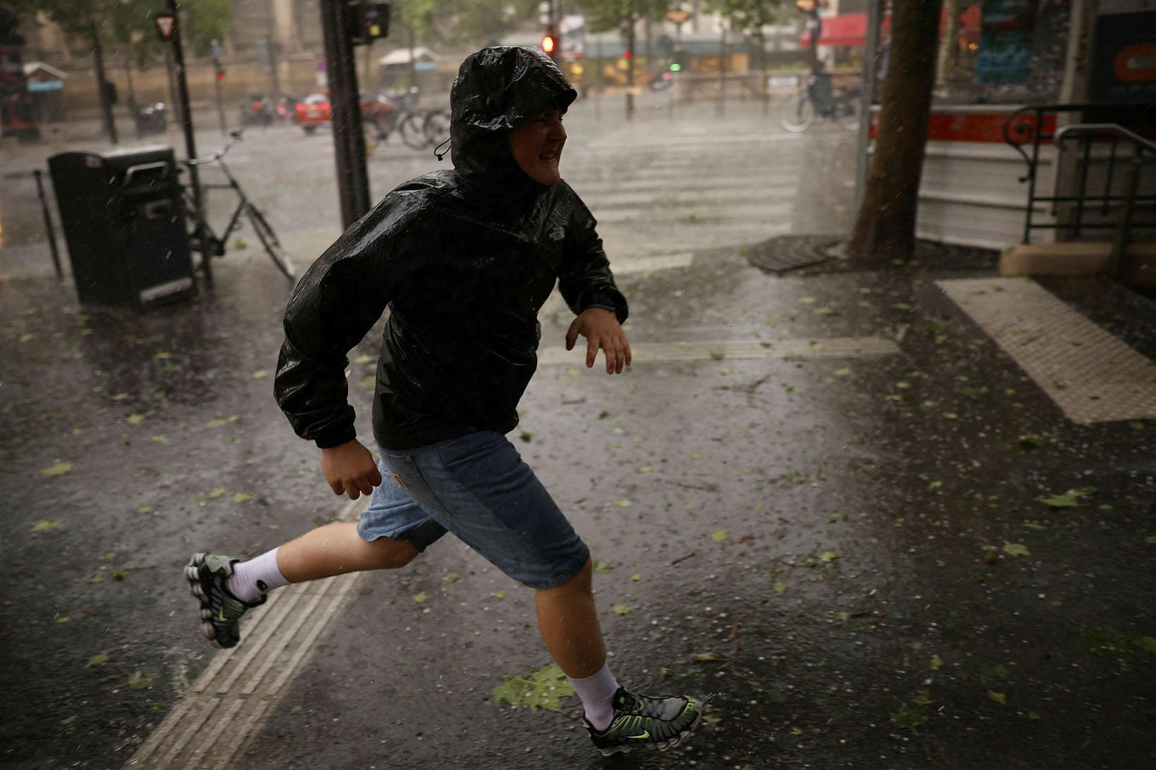 Manneskja hleypur í skjól í París í dag.