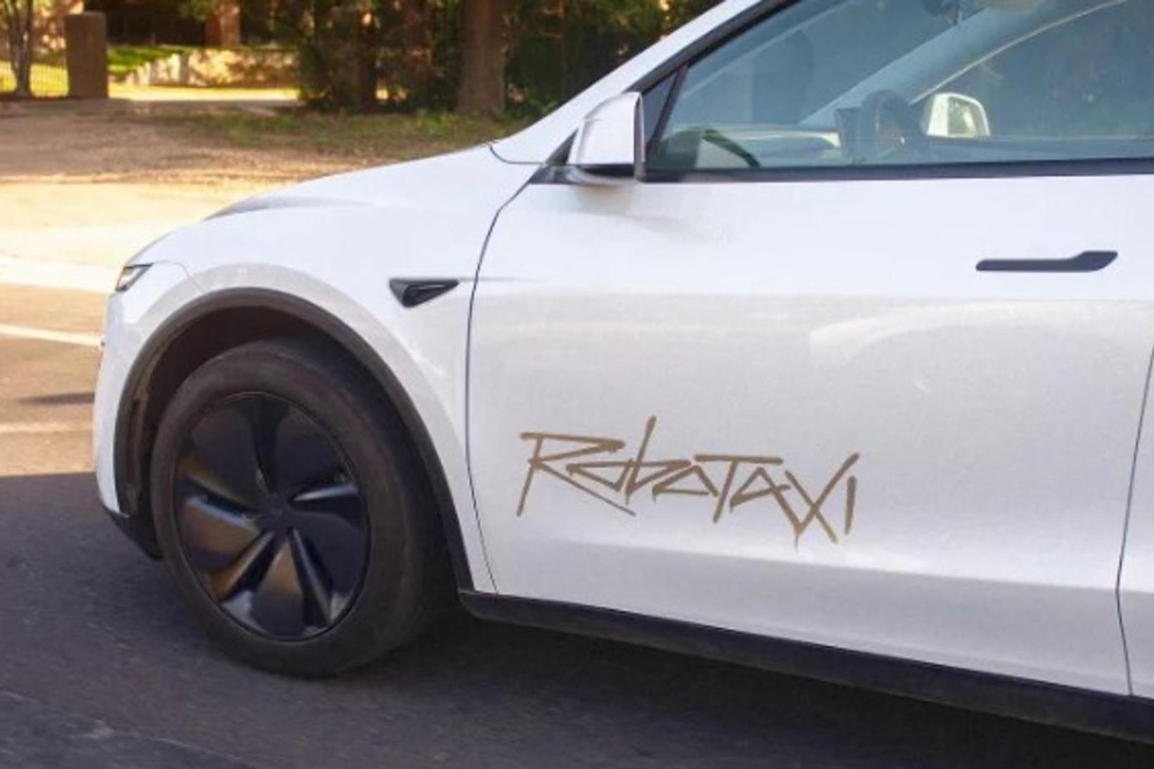 Robotaxi-merkið er skrifað í graffítístíl á framhurðum bílanna.
