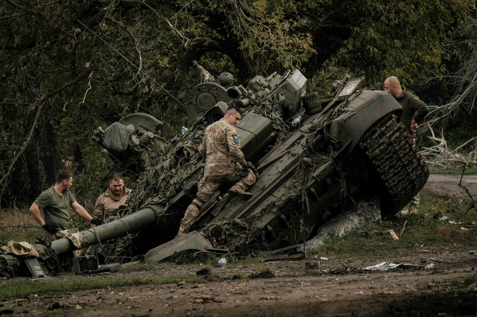 Úkraínskir hermenn skoða yfirgefinn rússneskan skriðdreka af gerðinni T-90A fyrr …