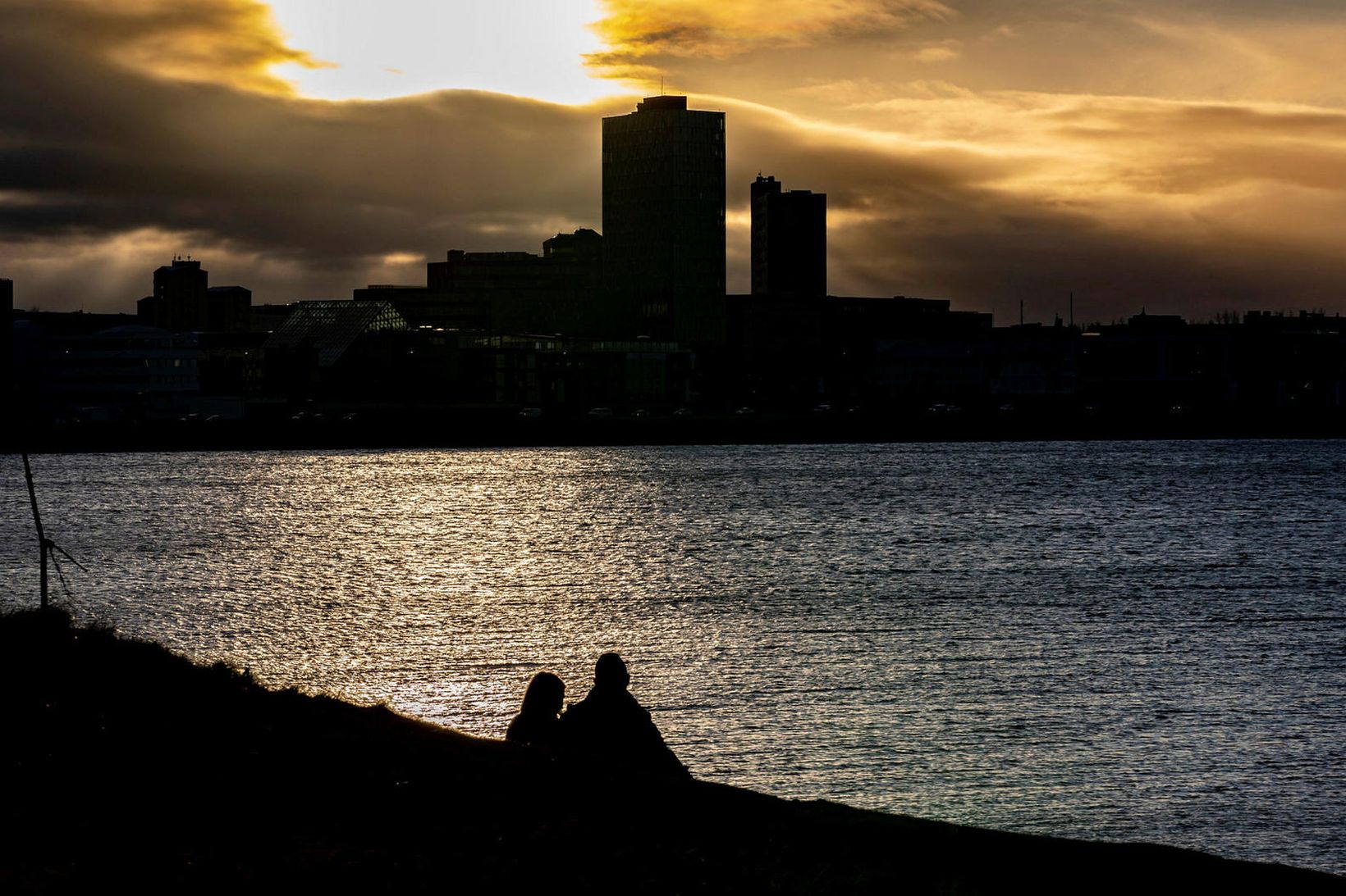 Fólk að horfa á ljósagang frá Lauganesi.