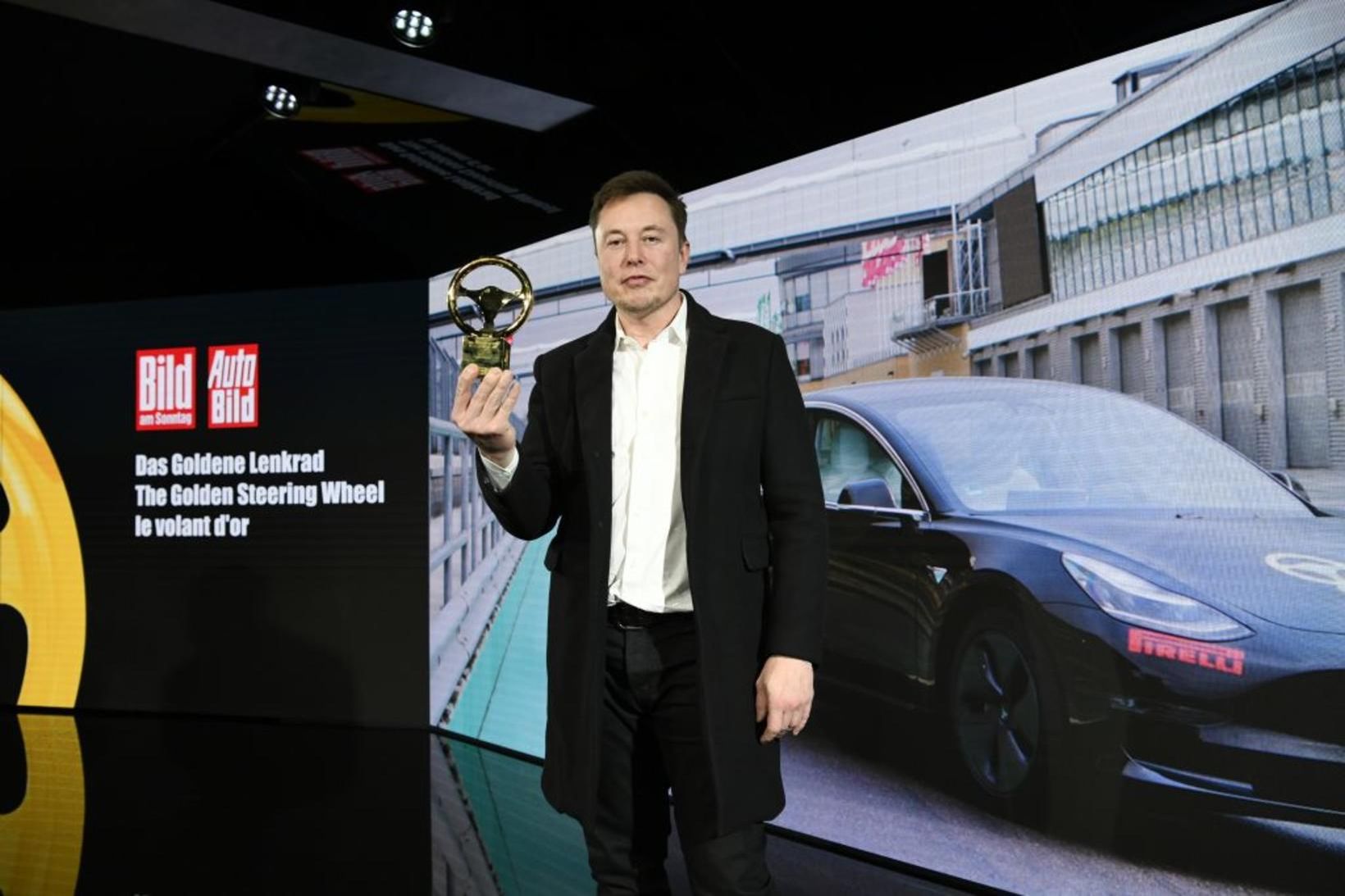 Elion Musk með gullstýrið þýska sem Model 3 færði honum.