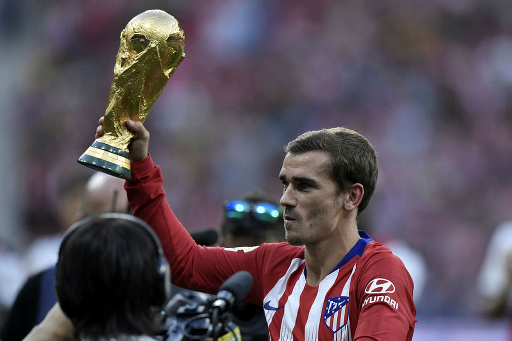 Antoine Griezmann sýnir stuðningsmönnum Atlético Madrid heimsmeistarabikarinn.