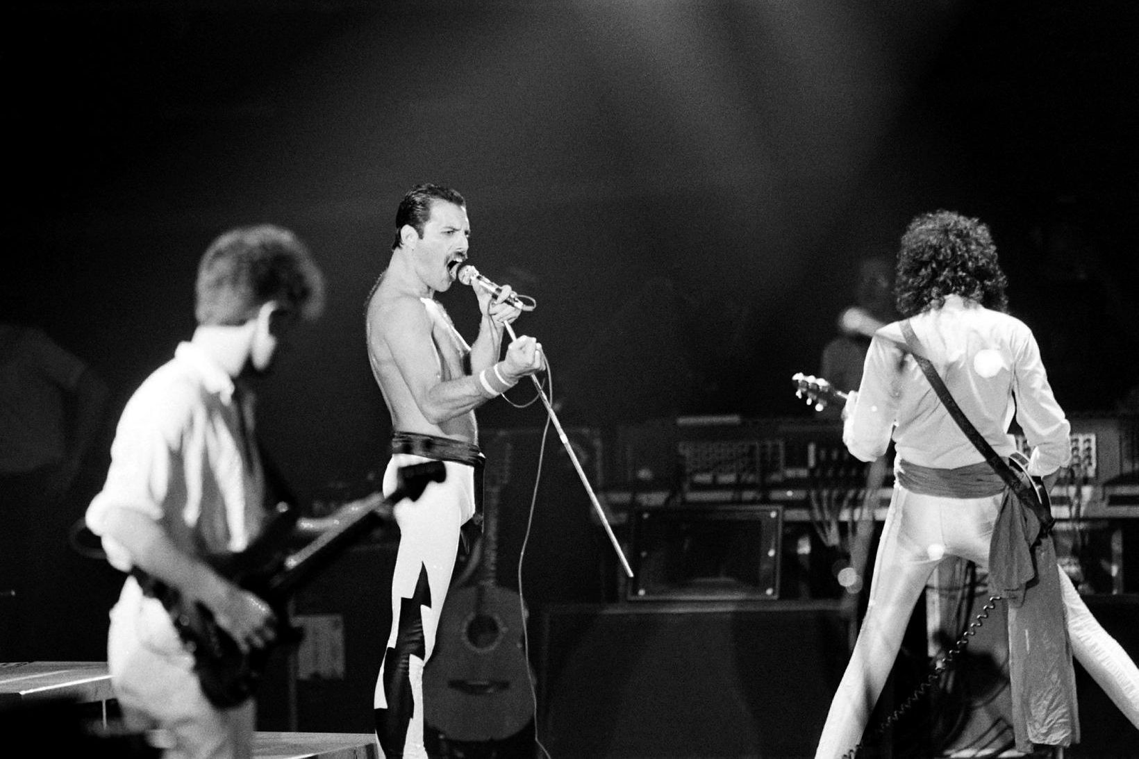 John Deacon, Freddie Mercury og Brian May á tónleikum í …