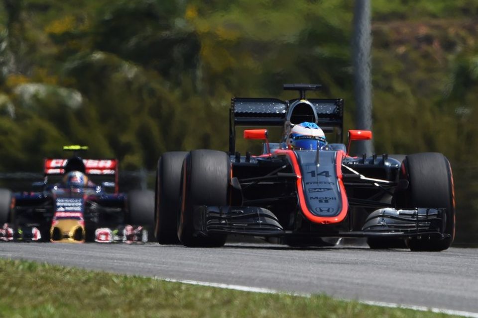 Fernando Alonso í beygju í Sepang í dag á undan Toro Rosso bíl.