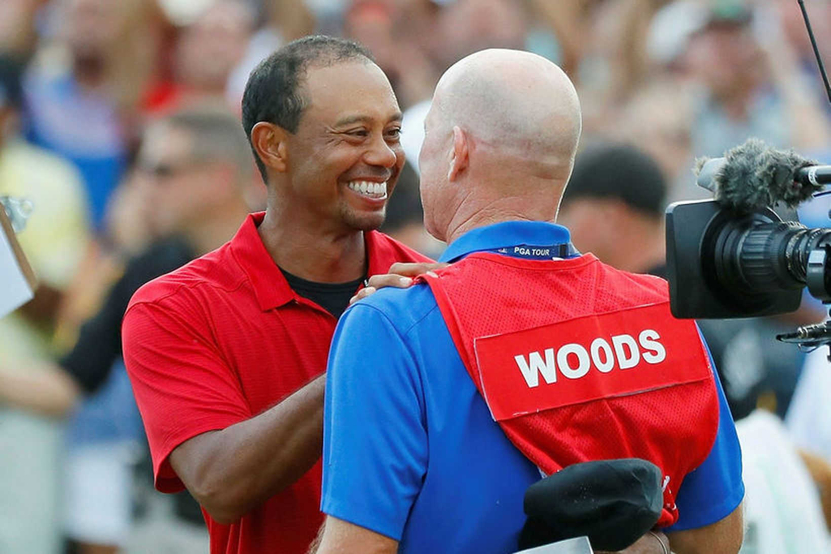 Tiger Woods fagnar með kylfusveini sínum Joe LaCava þegar sigurinn …