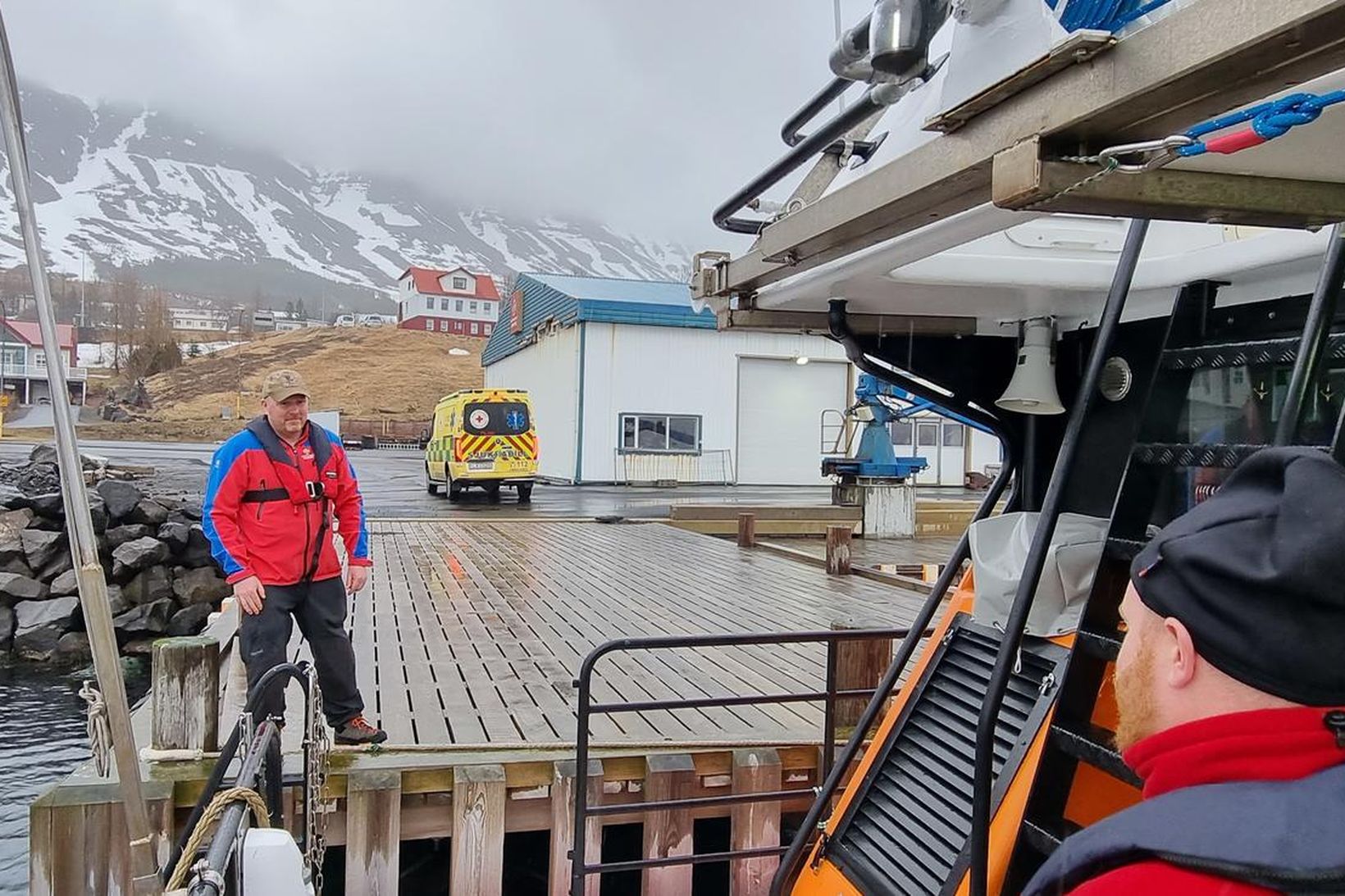 Sjúkrabíll mætir áhöfninni í Neskaupstað til að taka við sjúklingnum.