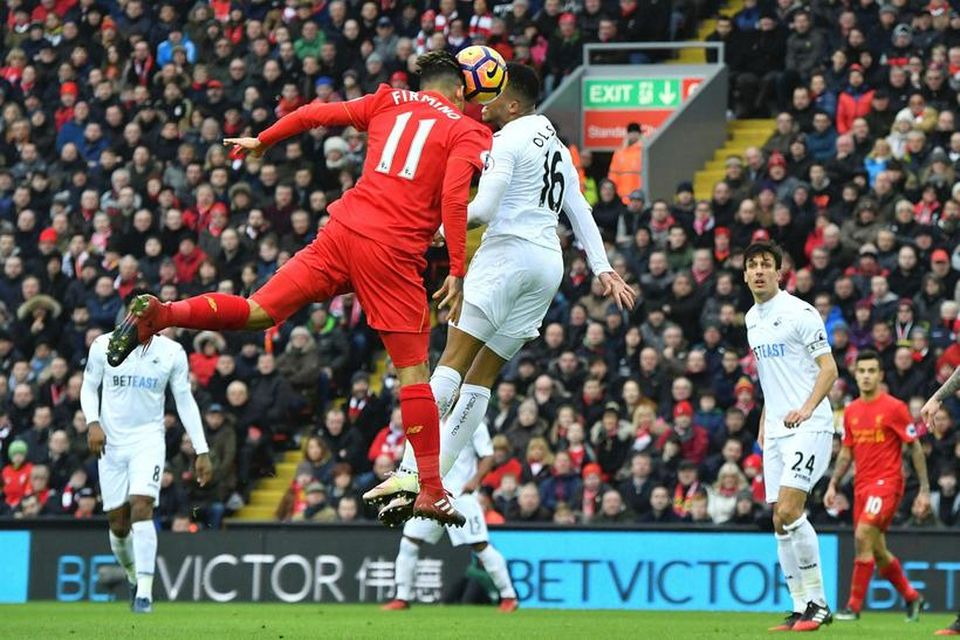 Roberto Firmino skorar fyrra mark sitt fyrir Liverpool gegn Swansea City í leik liðanna í …