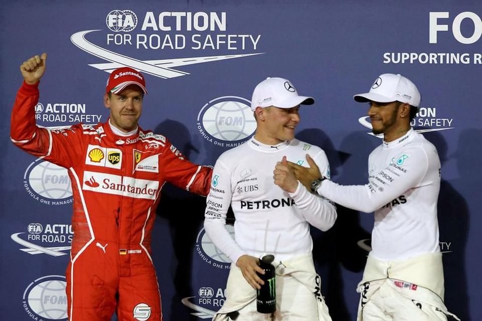 Lewis Hamilton (l.t.h) og Sebastian Vettel samgleðjast Valtteri Bottas (í miðjunni) með ráspól hans í …