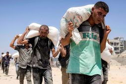 Palestínumenn með hveitipoka sem fluttir voru inn á Gasasvæðið í gær.
