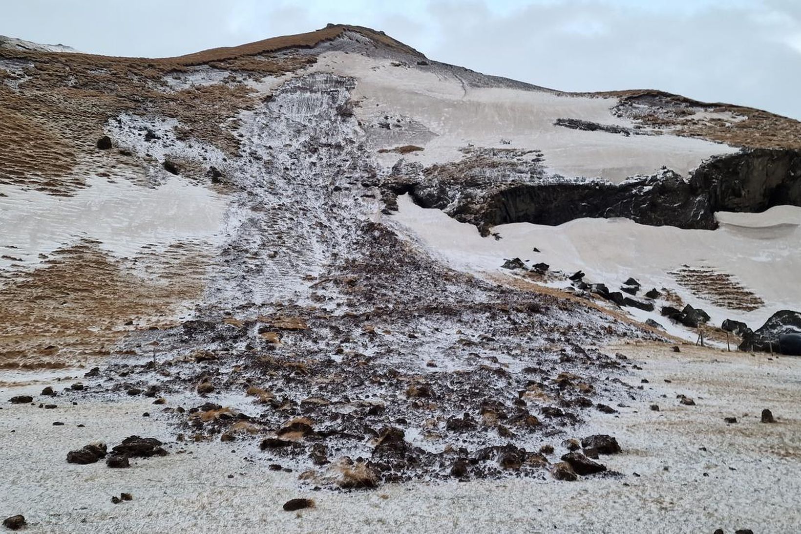 Undir giljum og lægðum þar sem enn er snjór getur …