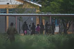 Hermenn fylgja háskólanemum sem haldið var í gíslingu út af háskólasvæðinu í Garissa í dag.