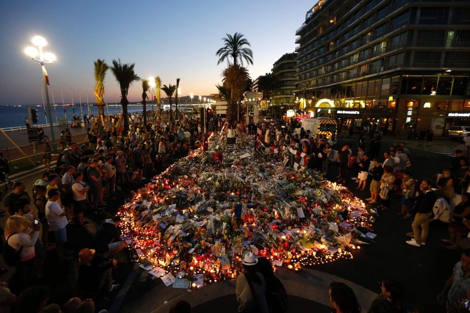 Fólk safnast saman við götuna Promenade des Anglais í Nice þar sem maður ók flutningabíl …
