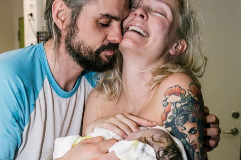 Andrea and her boyfriend holding their newborn son.