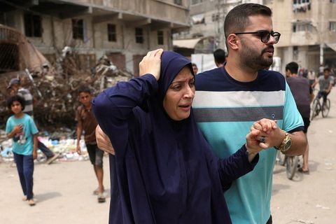 Palestínskur maður aðstoðar særða konu í Gasaborg í kjölfar þess er ísraelski forsætisráðherrann Benjamín Netanjahú …