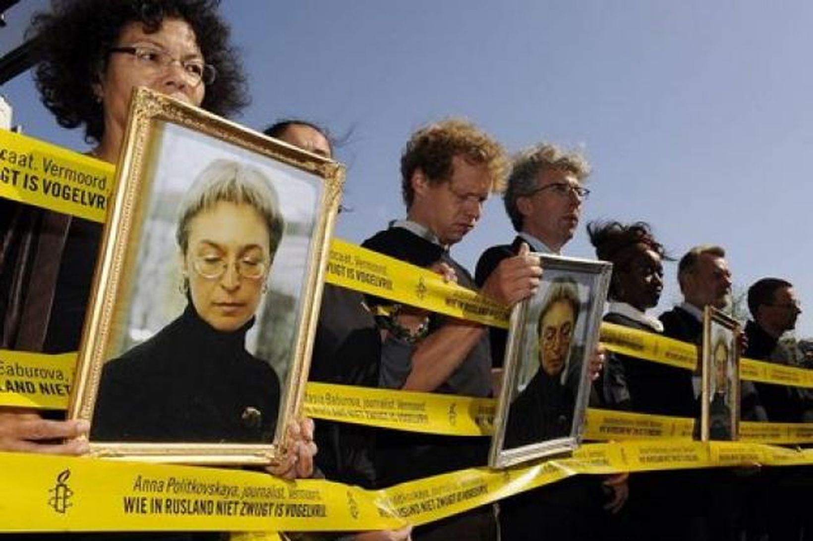 Mótmælendur halda uppi myndum af Önnu Politkovskayu í tilefni af …