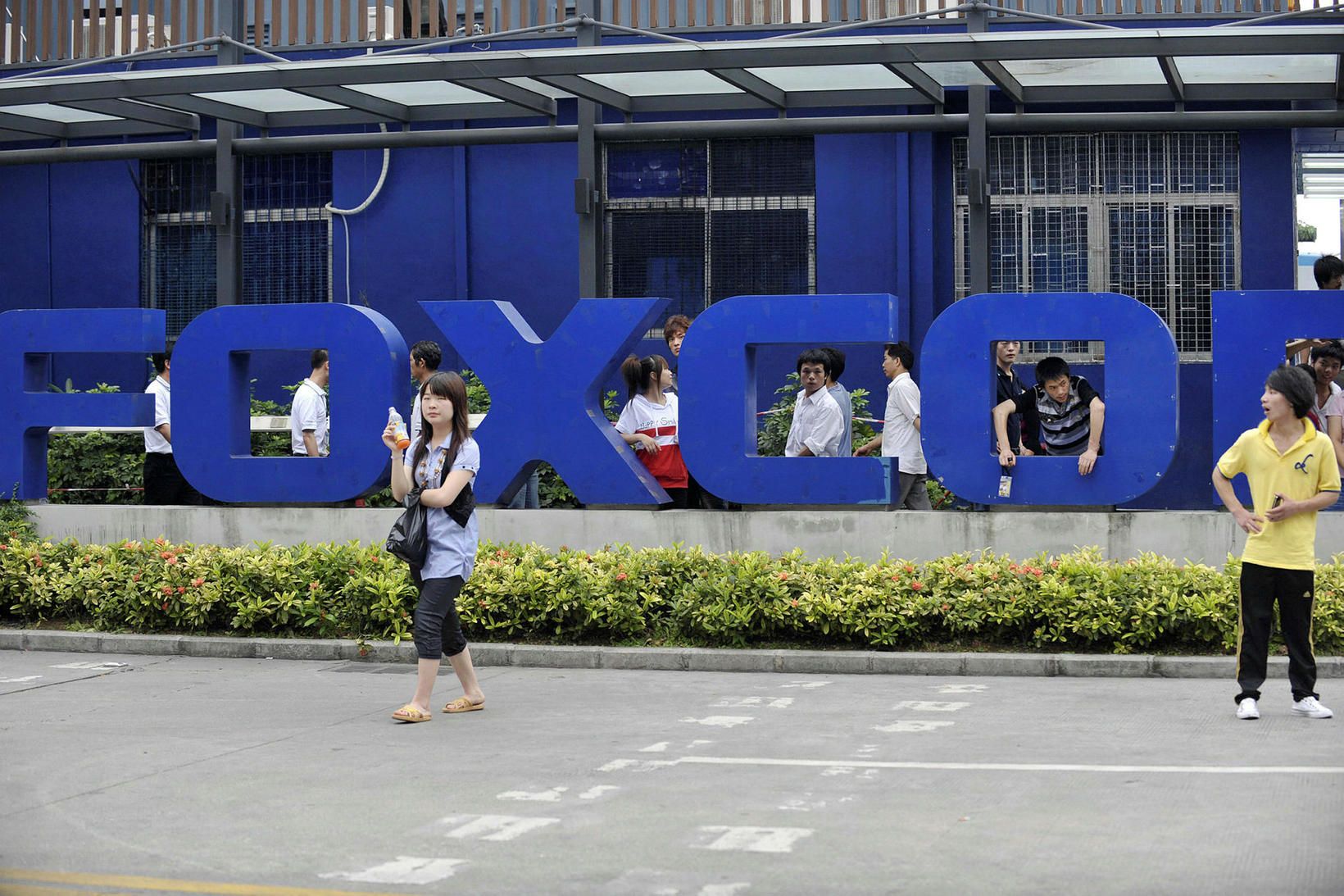 Starfsmenn fyrir utan verksmiðju Foxconn í borginni Shenzhen í héraðinu …