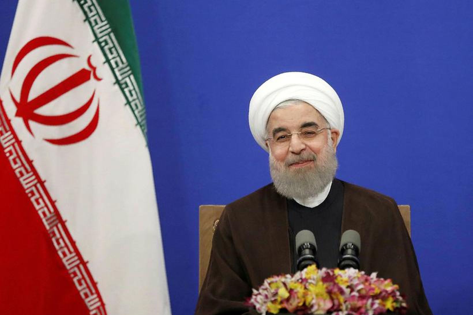 Rouhani brosir er hann heldur ræðu í Tehran á laugardag.