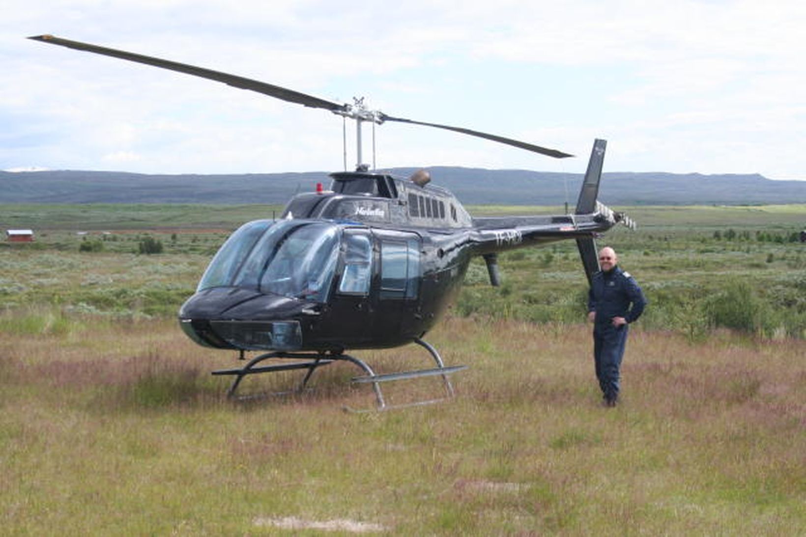 Guðjón Skarphéðinsson þyrluflugmaður Norðurflugs á flötunum við Geysi.