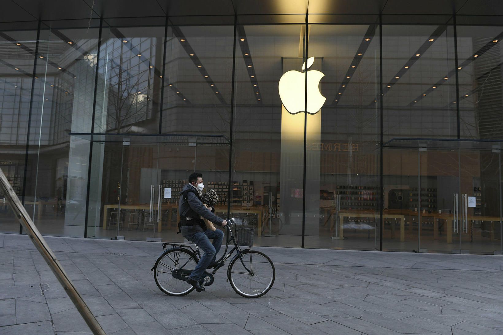 Maður hjólar fram hjá Apple-búðinni í Peking fyrr í þessum …