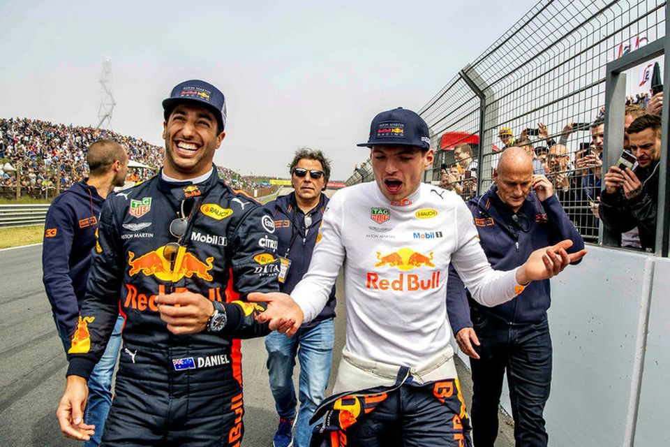 Daniel Ricciardo (t.v.) með vörumerki sitt á lofti, skælbrosið, eftir að liðsfélagi hans Max Verstappen …