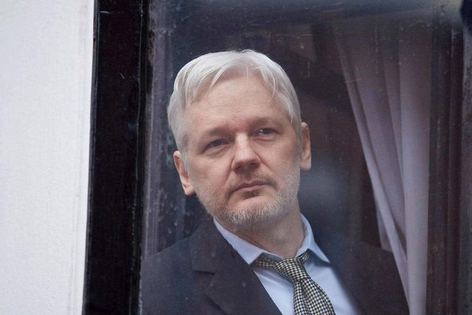 Julian Assange úti í glugga í sendiráði Ekvador í London. …