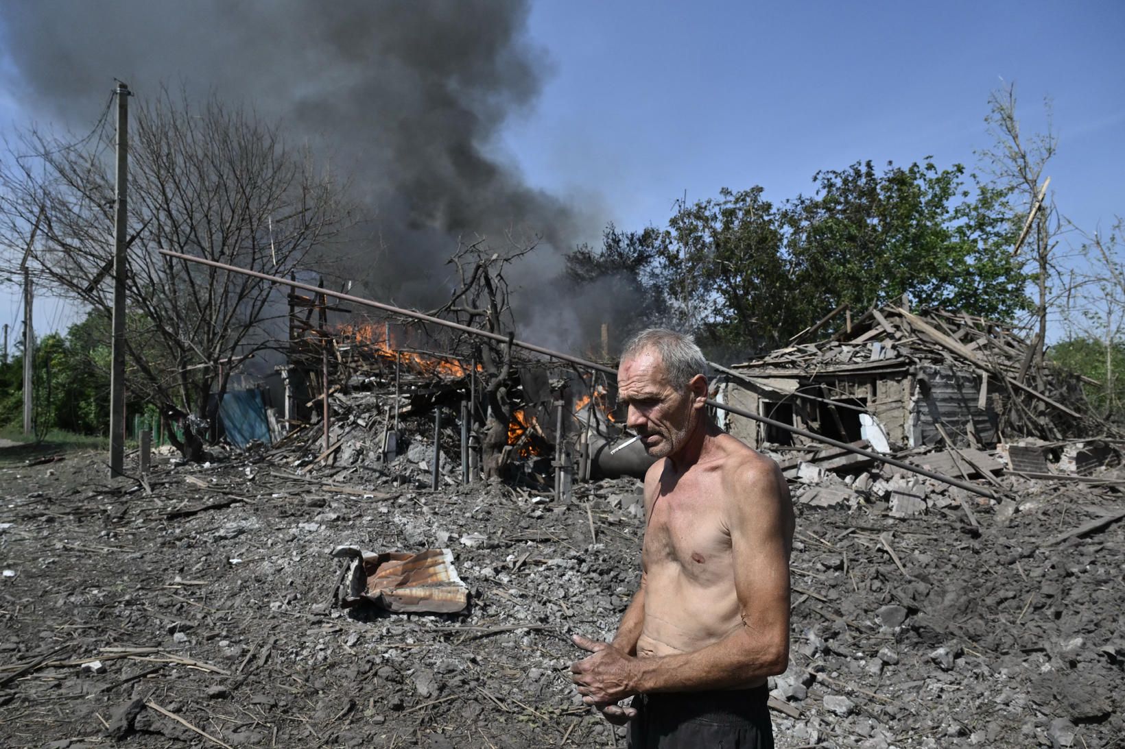 Íbúi bæjarins Myrnograd í Donetsk-héraði fyrir utan húsnæði sem brann …