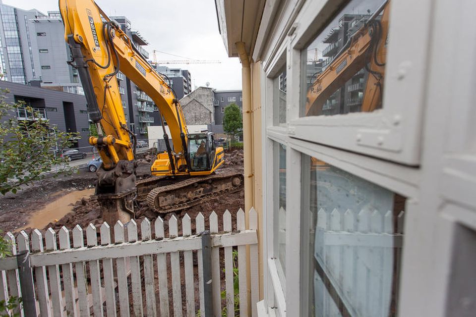 Í morgun voru stórvirkar vinnuvélar að brjóta niður berg við hlið grindverksins á leikskólalóðinni með …