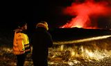 Viðbragðsaðli ásamt ferðamanni við Grindavíkurveg virða fyrir sér gosið nú á áttunda tímanum.