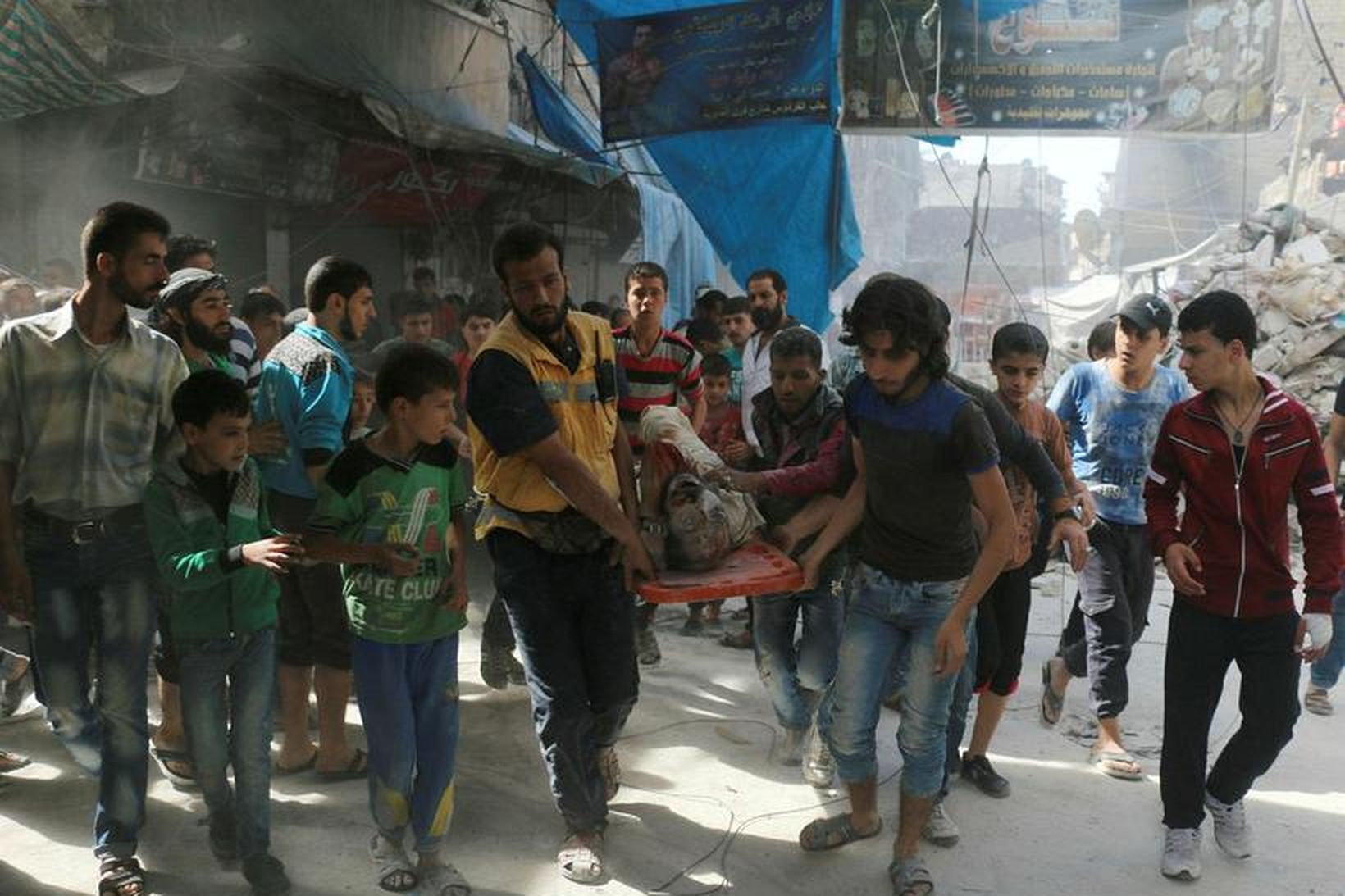 Sýrlendingar halda á líki manns eftir loftárásir á Aleppo.