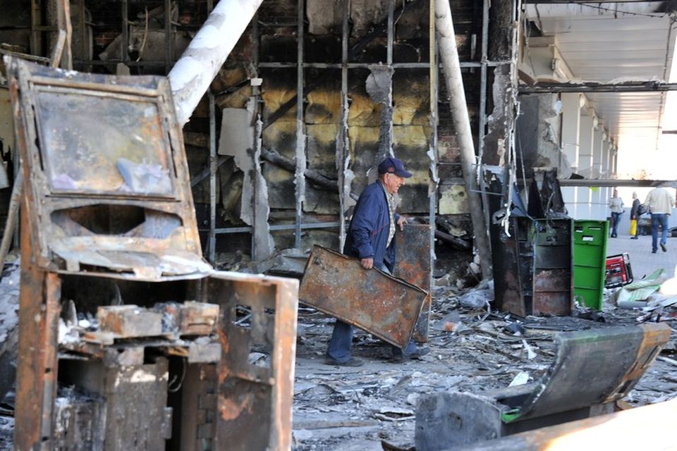 A man carries fragments of metal constructions from Privat Bank building burned by pro-Russian activists …