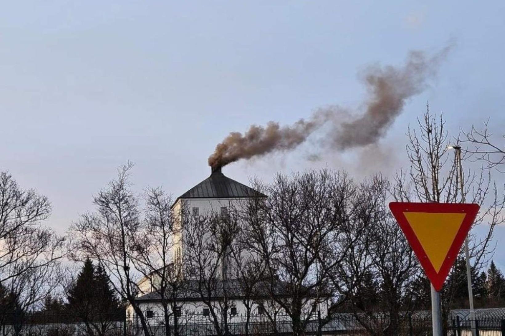 Dökkan reyk leggur frá bálstofunni þegar líkbrennsla fer fram.