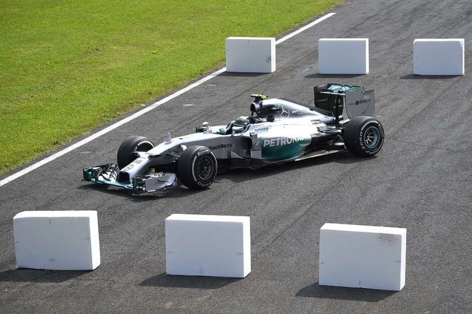 Nico Rosberg skáskýtur sér á milli frauðplast stólpa á flóttaleiðinni við fyrstu beygju í Monza.