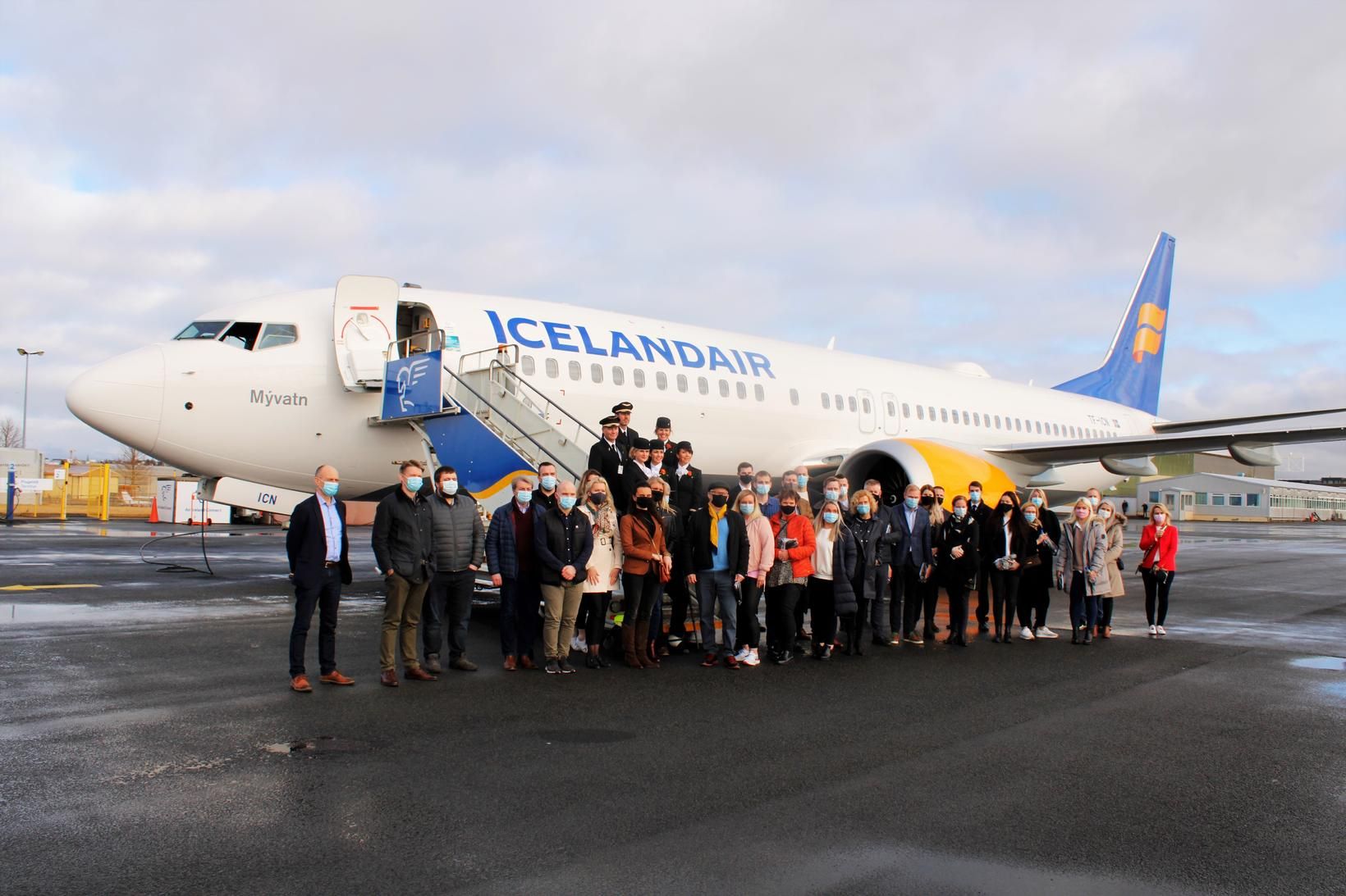 Farþegar í fluginu við vélina eftir lendingu á Reykjavíkurflugvelli í …
