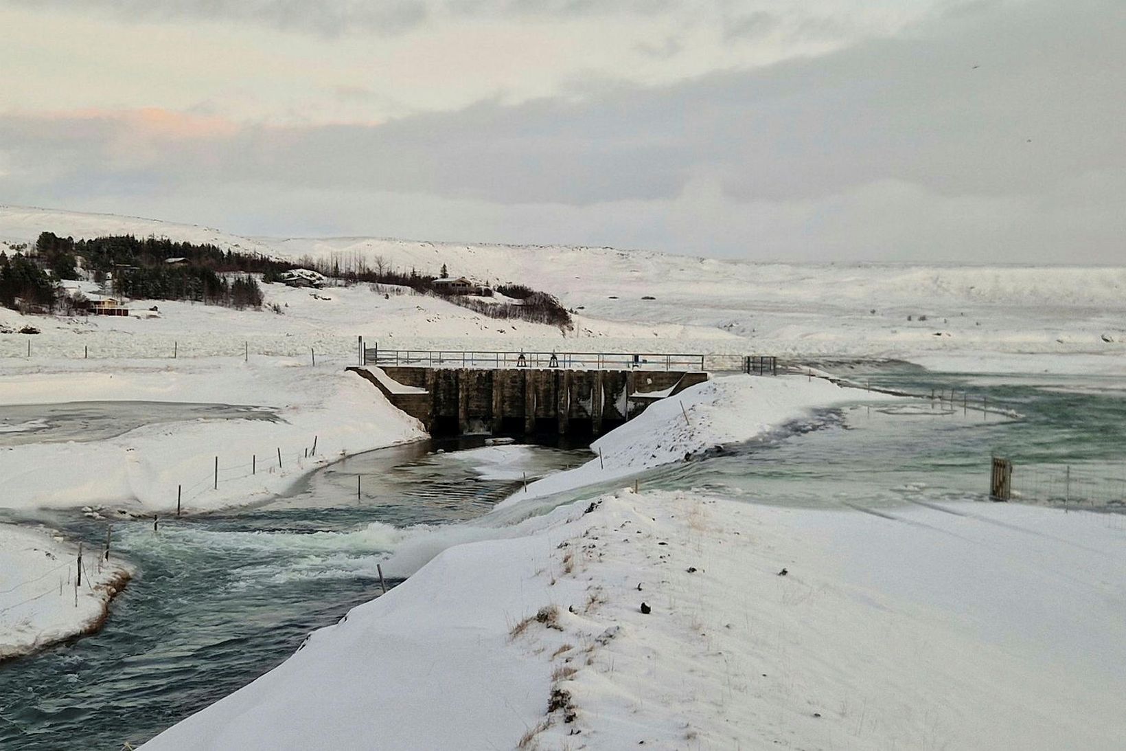 Áveituskurðurinn og flóðgáttin. Hvítá í hvarfi og í fjarska sjást …